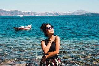 Girl in dress with black shades on the beach