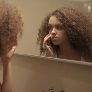 Imagine of woman looking at face in mirror